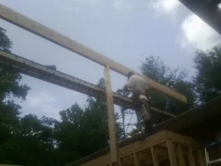 Carpenter setting a ridge beam over a new addition frame — Ice Dam Removal by Roofing Brothers in Fredericksburg
