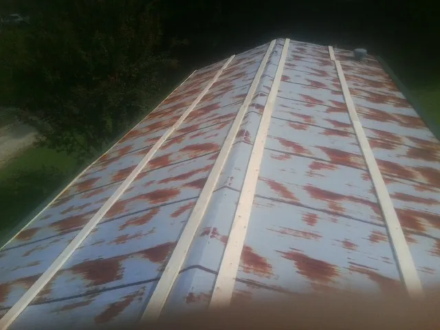 Rusted metal roof panels with new wood purlins before replacement — Storm Damage Roof Repair in Fredericksburg by Roofing Brothers